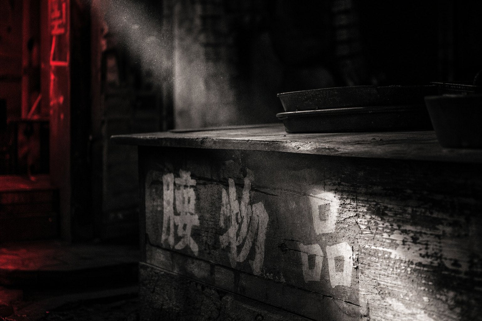 Weathered painted signage lit by a single shaft of light